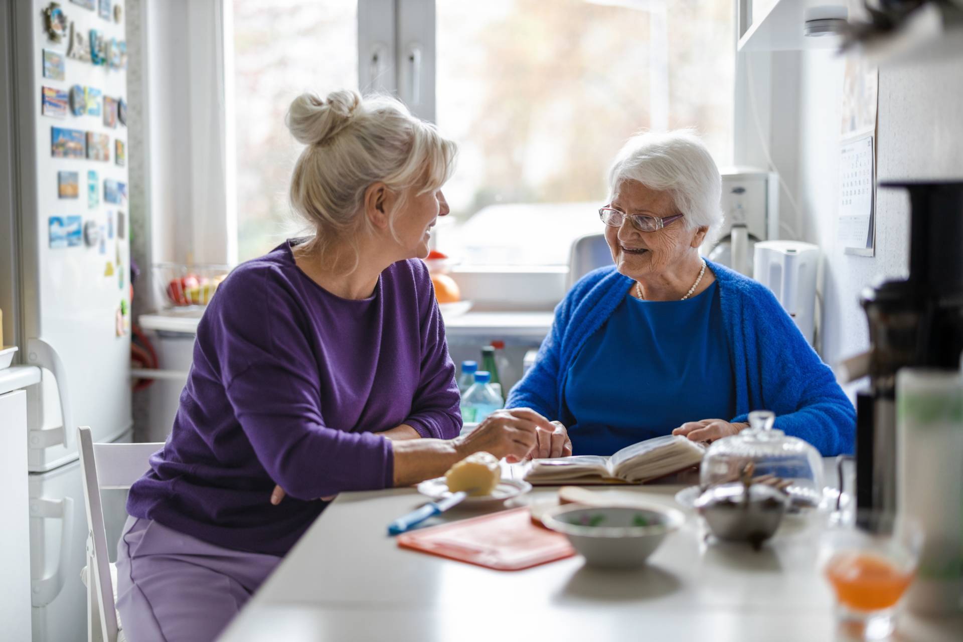A mom sitting with her daught who is coping with her aging parent.