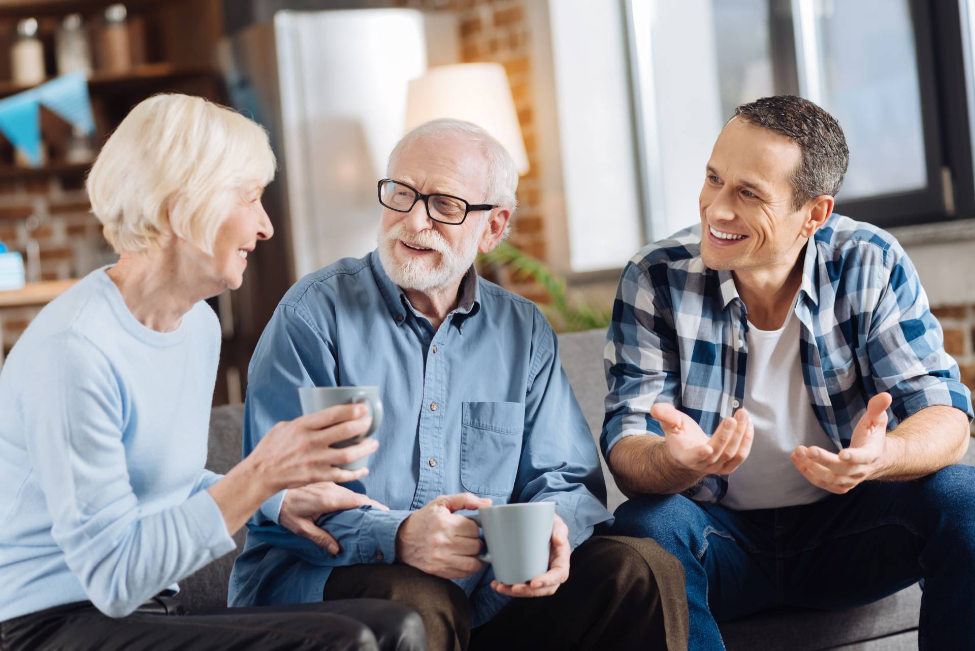 An adult talking to his aging parents about their future on the couch.