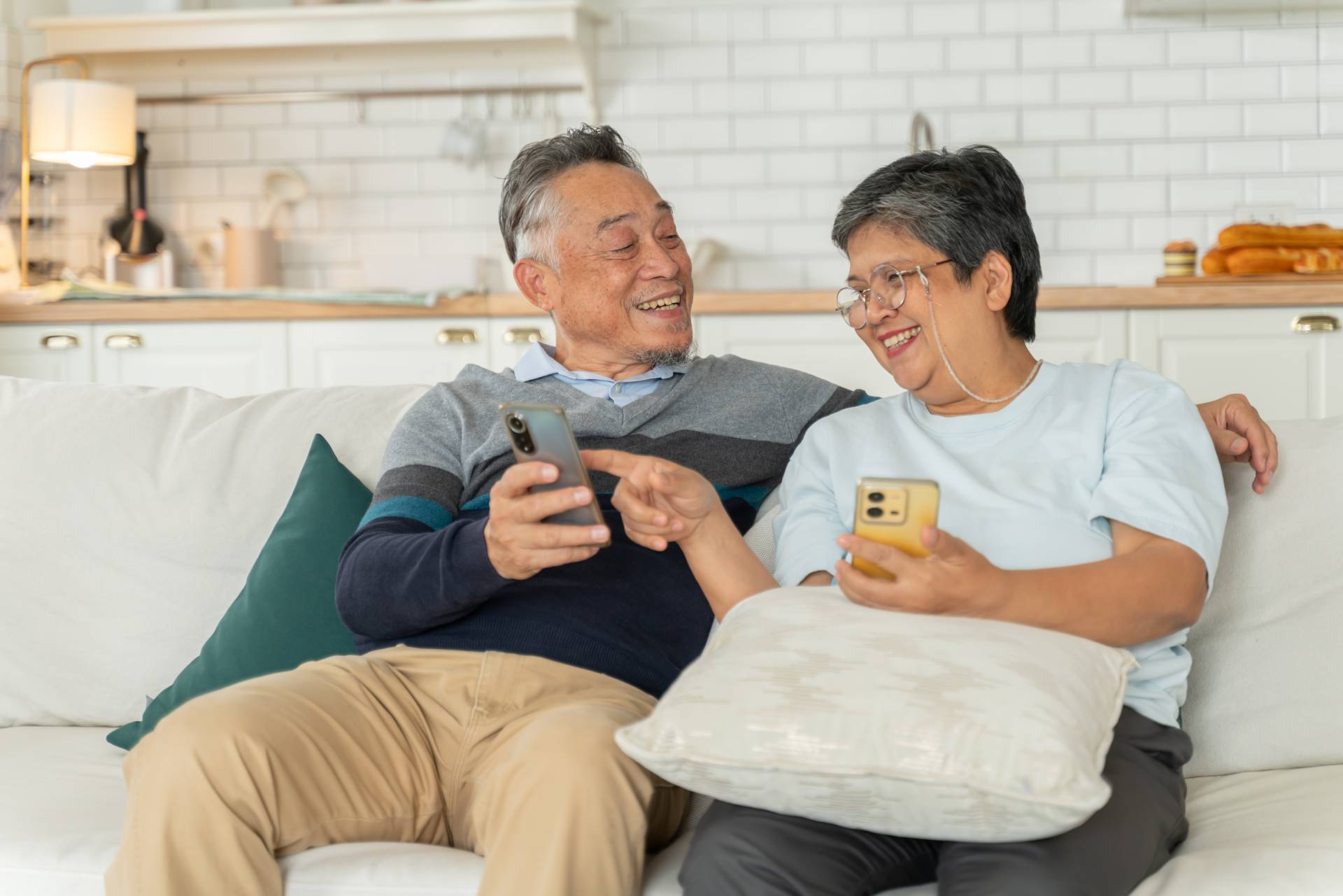 An elderly couple playing trivia on their phones together