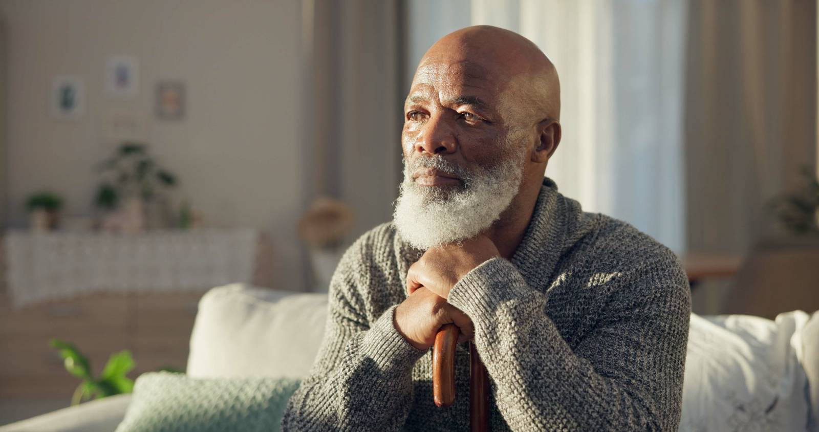 A man sitting on a couch looking out the window.
