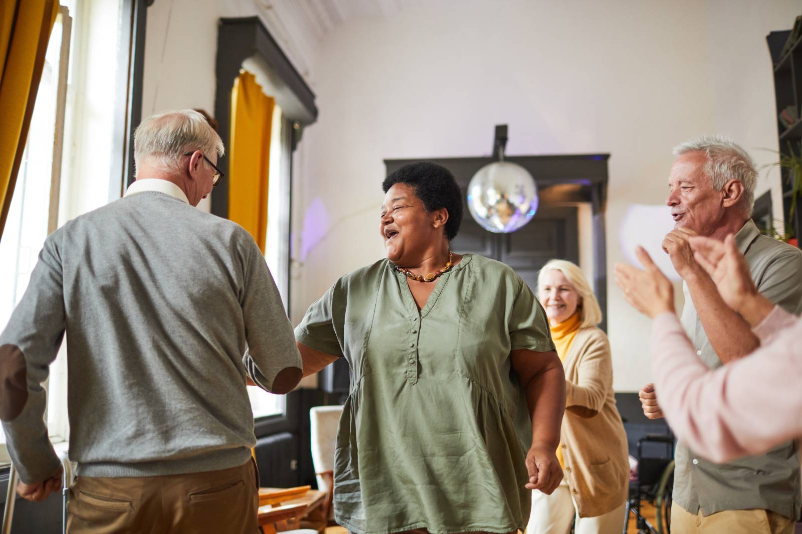 Seniors with dementia dancing together.