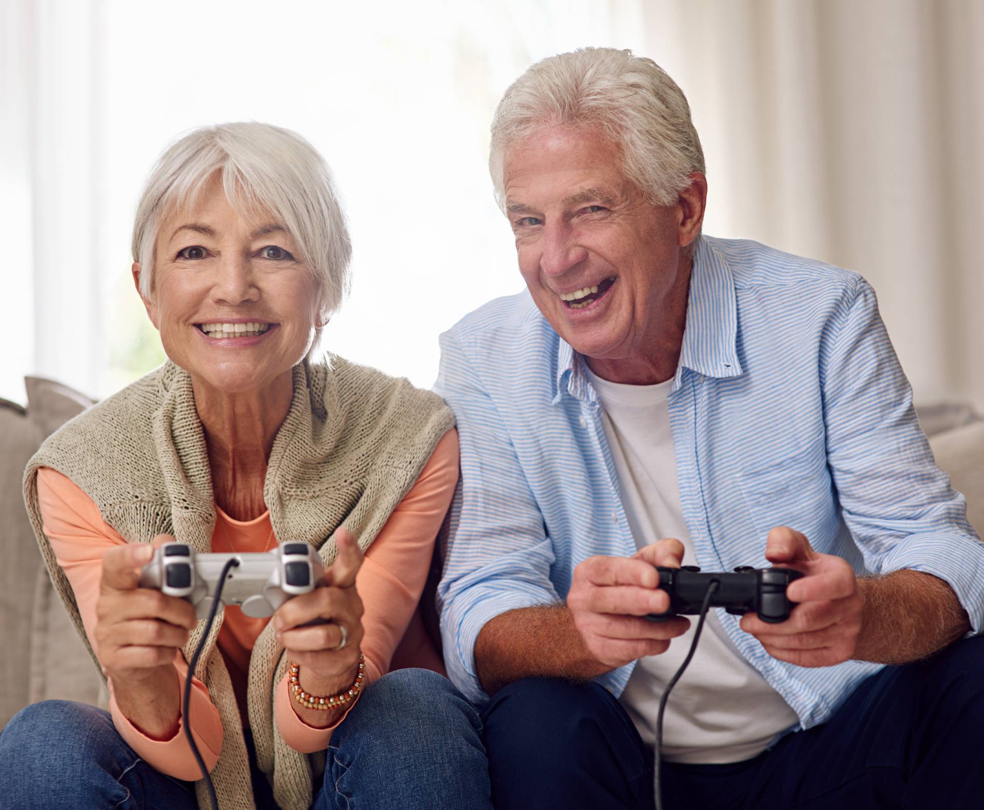 Two seniors having fun playing video games together