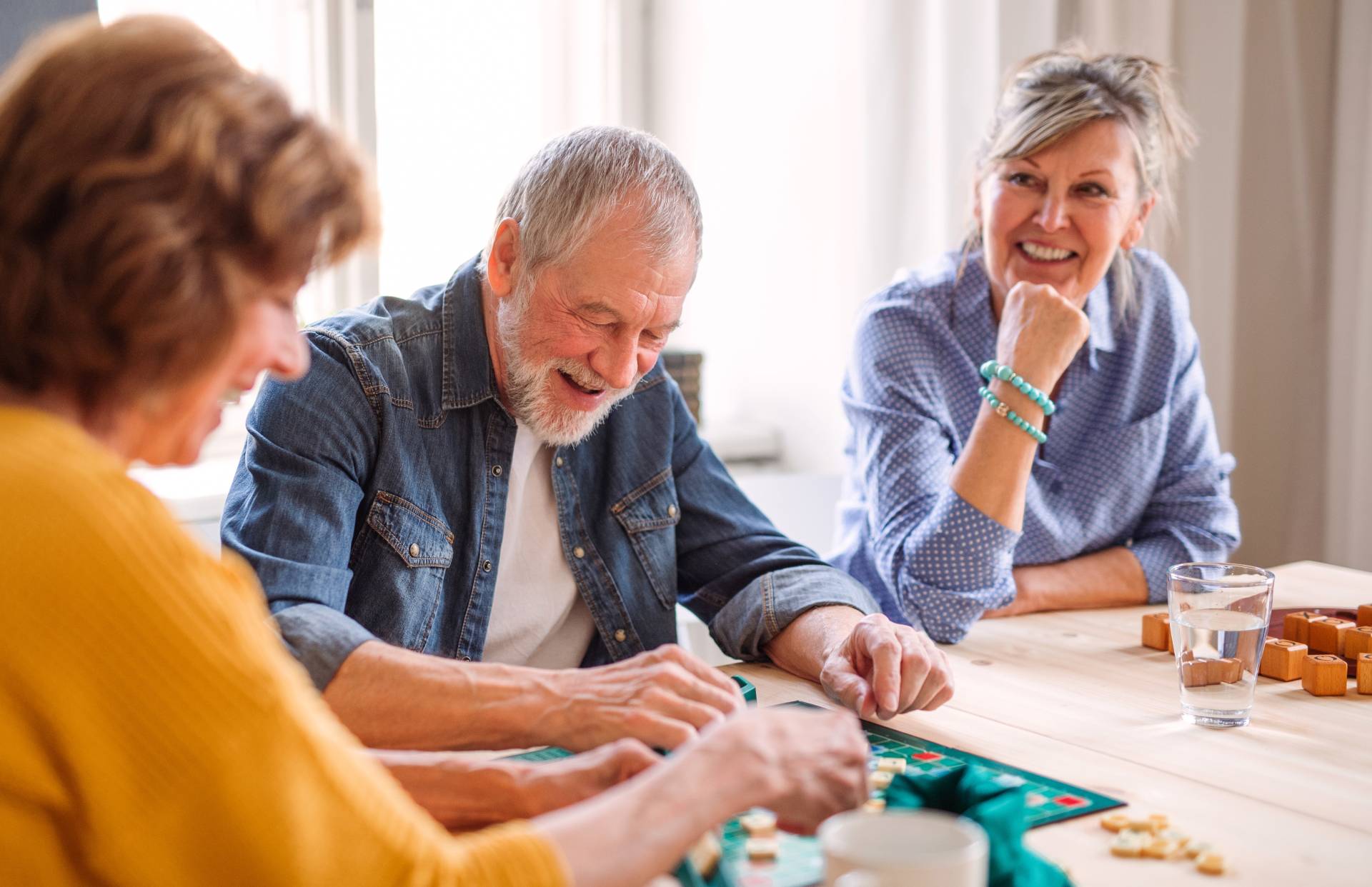 Three seniors having fun playing a board game together