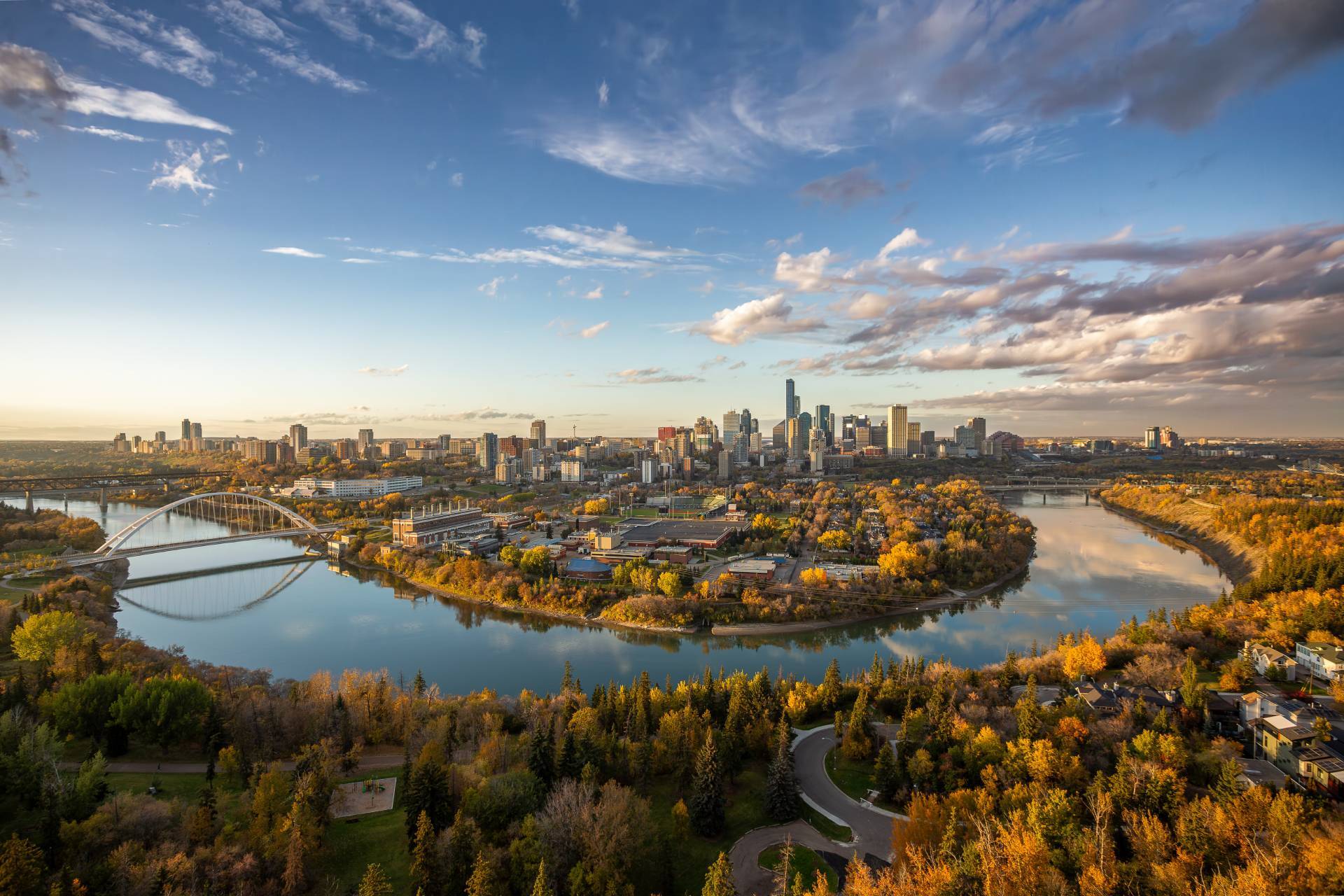 Aerial view of the Edmonton skyline and Walterdale Bridge over the North Saskatchewan River, surrounded by autumn trees