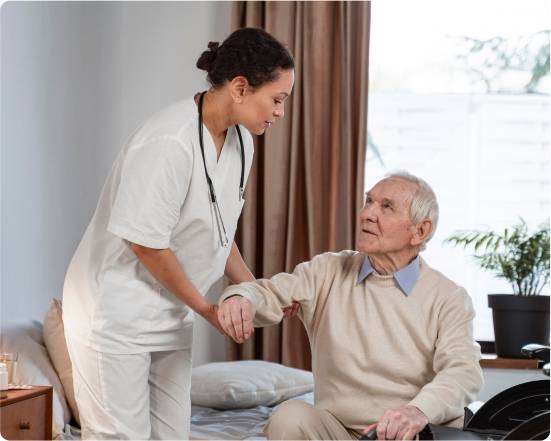 Why Choose Ohana Care for Live-In Support_-image Caregiver helping an elderly man stand up from a bed at home