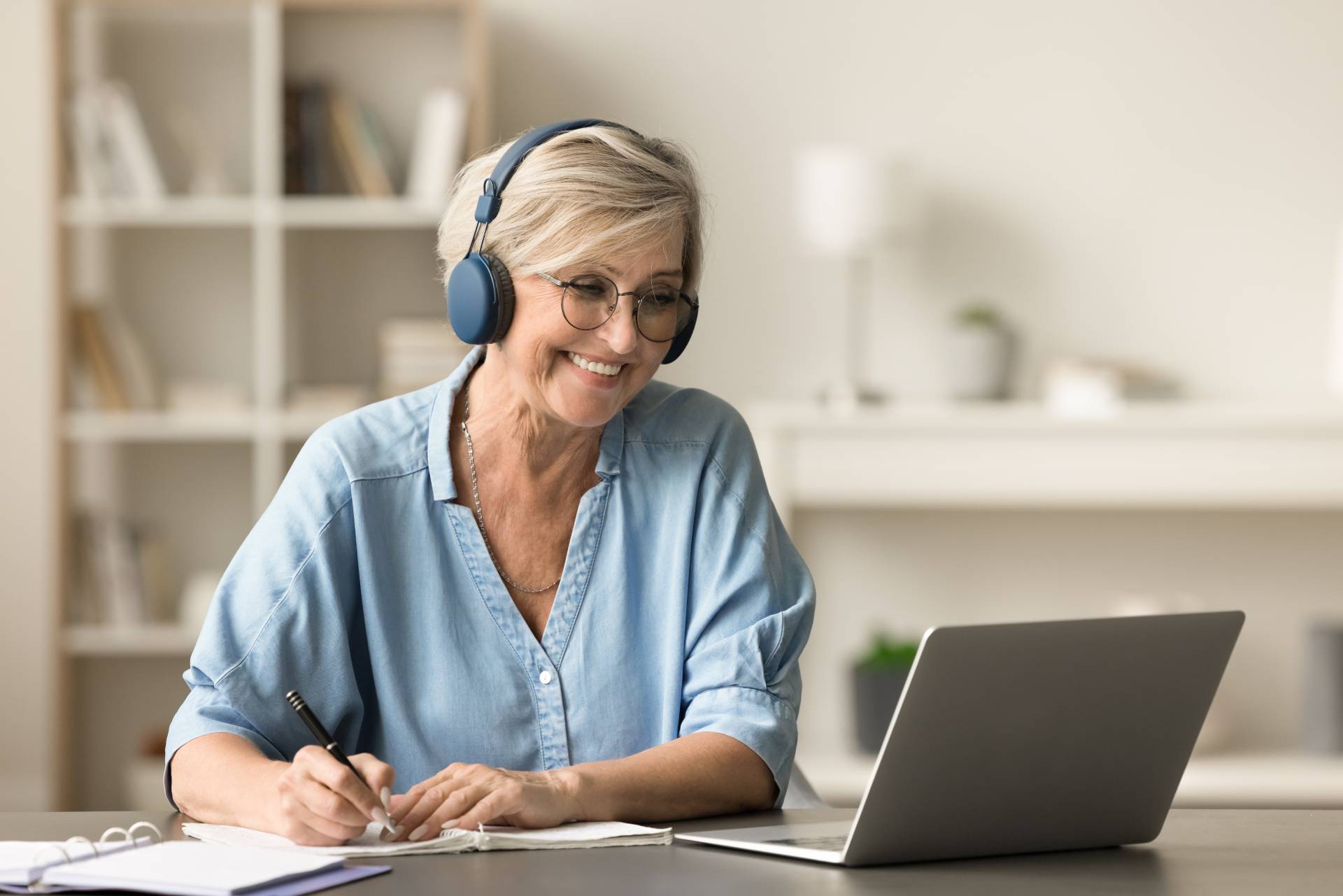 An elderly woman using online resources on her computer to learn a language